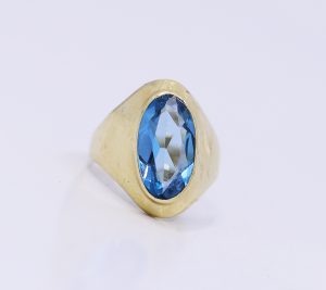 Zlatý prsten s velkým modrým kamenem